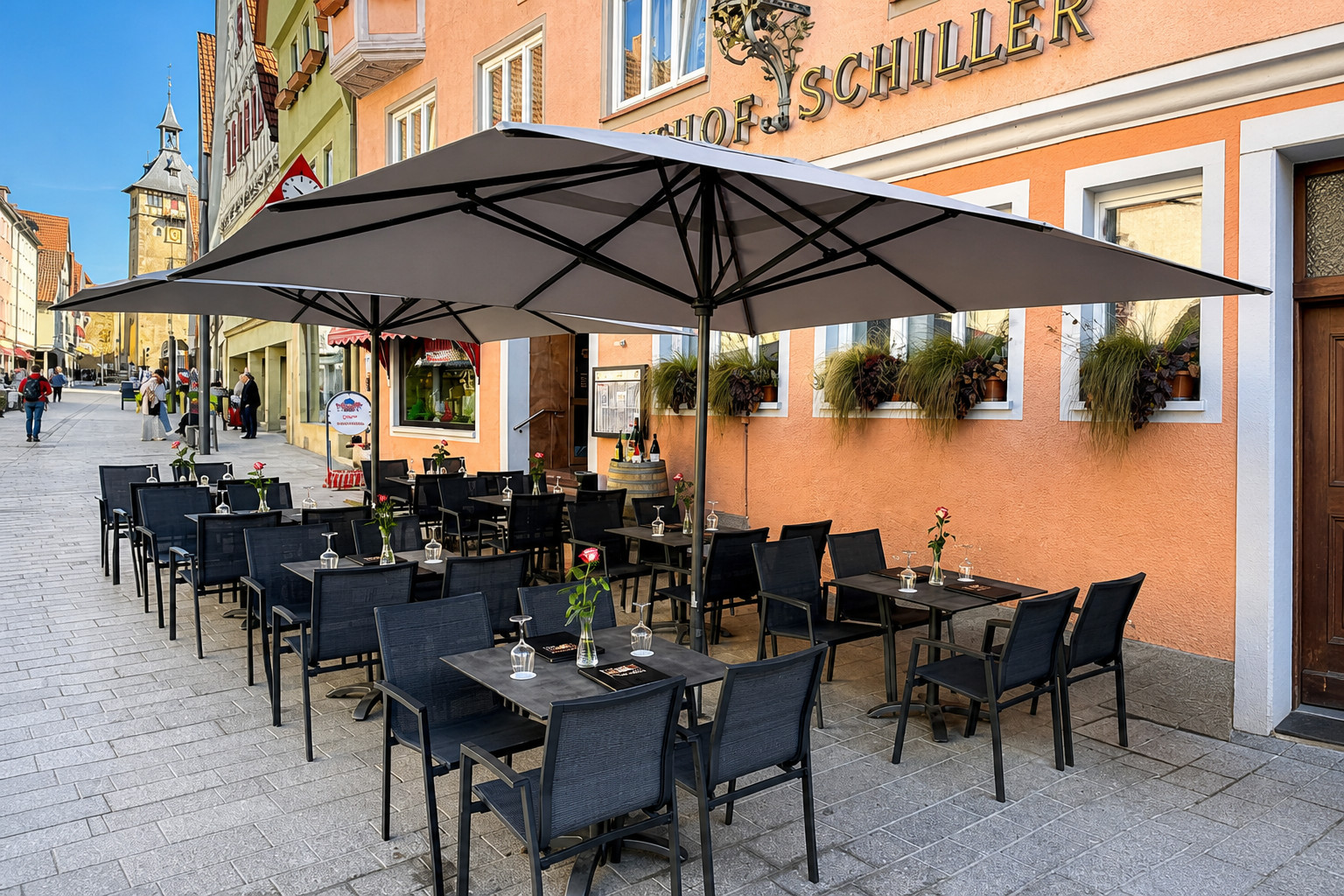 Sonnige Terrasse mit Sonnenschirmen am Marktplatz in Marbach am Neckar – Restaurant Schillerhof Pnishi