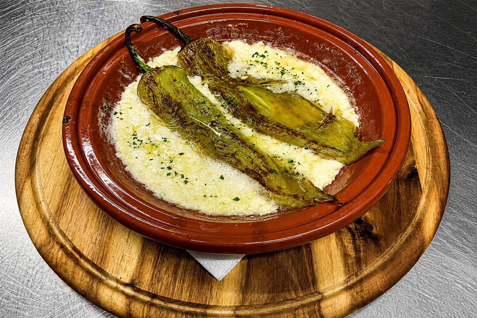 Gegrillte Peperoni in cremigem Kajmak, serviert in der Tonschale – Restaurant Schillerhof Pnishi