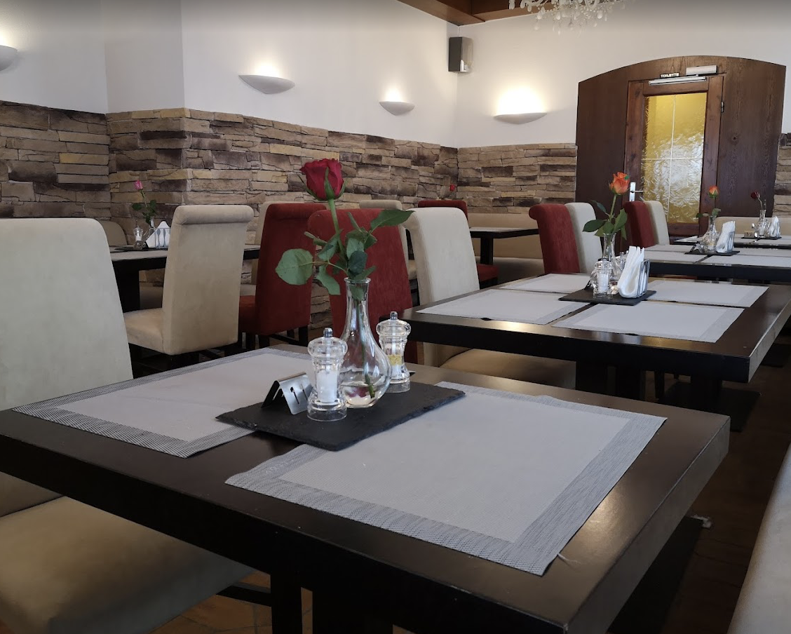 Moderner Gastraum mit Steinkachelwand und gedeckten Tischen – Restaurant Schillerhof Pnishi